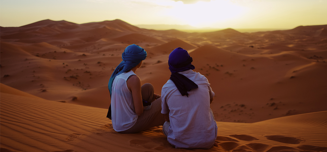 Romantic Couple Observing the Moroccan Sahara Desert Sunset