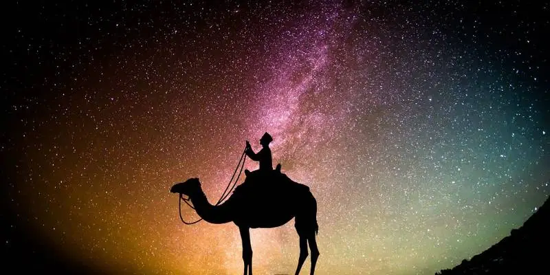 A nomadic Moroccan rides a camel in the desert under a starry sky, searching for the moon to signal the start of Ramadan.